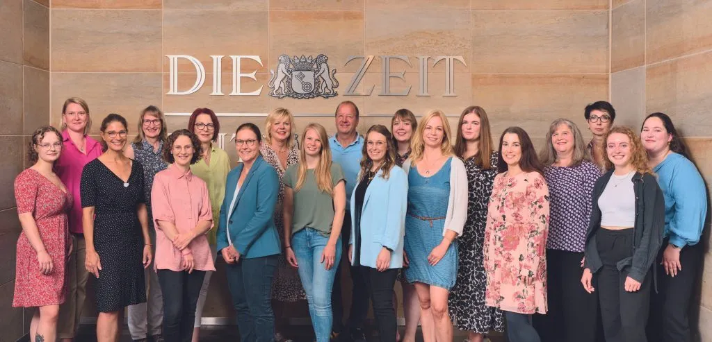 Teamfoto einer Gruppe von Personen vor einer modernen Büro-Kulisse