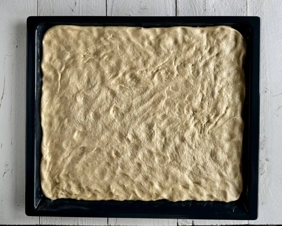 Teig auf Backblech für Hefe-Apfelkuchen mit Streusel.