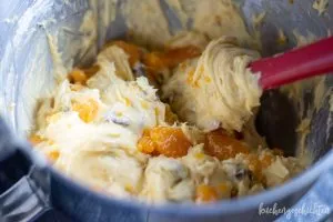 Teig mit KitKats und Mandarinen in der Kastenform verteilen