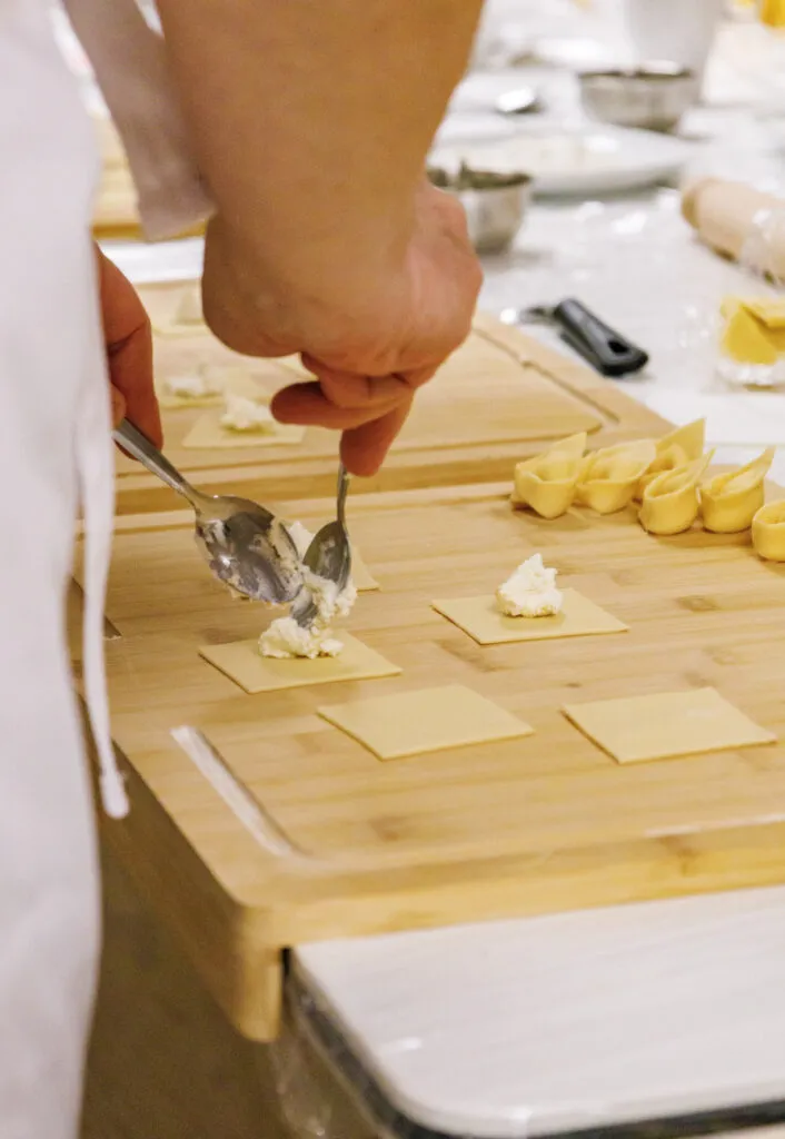 Teilnehmer lernen in einem Pasta-Workshop, Tortellini und andere Nudelsorten zu formen