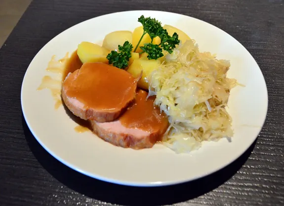 Teller mit Kasseler, serviert mit Sauerkraut und Salzkartoffeln, ein deftiges Gericht aus der DDR-Küche