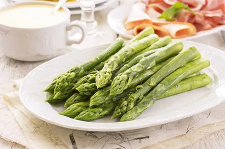 Tenderly cooked green asparagus on a plate, ready to serve as a cholesterol-lowering vegetable meal.