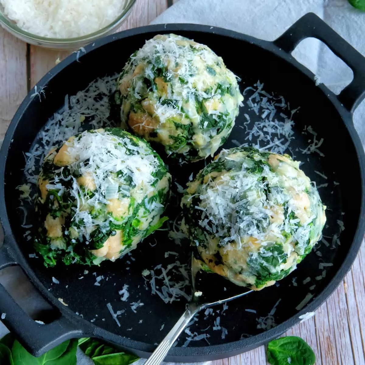 Tiroler Spinatknödel mit Parmesan und brauner Butter auf einem Teller angerichtet