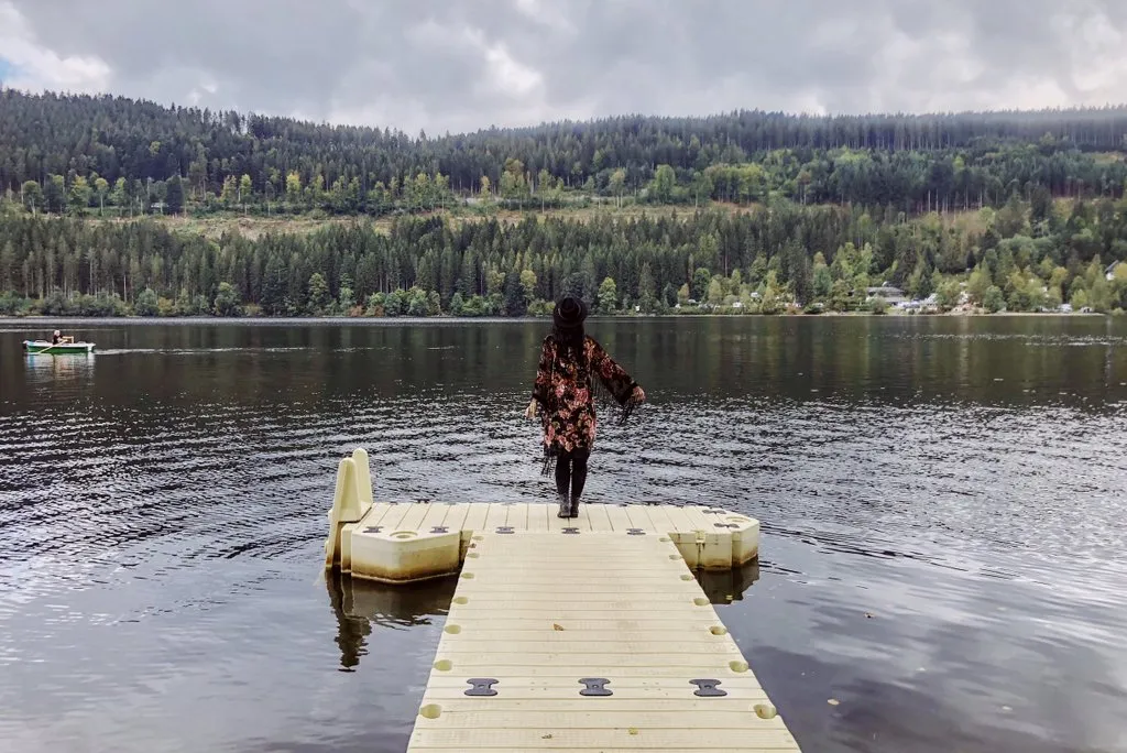 Titisee im Schwarzwald mit Booten auf dem Wasser und bewaldeten Ufern