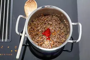 Tomatenmark wird zur Bolognese-Basis gerührt