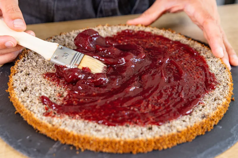 Tortenboden mit Kirschmarmelade bestreichen