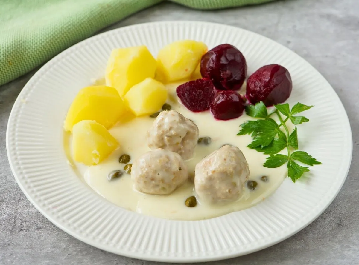 Traditionelle Königsberger Klopse mit Kapernsoße, Reis und einem Zitronenschnitz, zubereitet im Thermomix