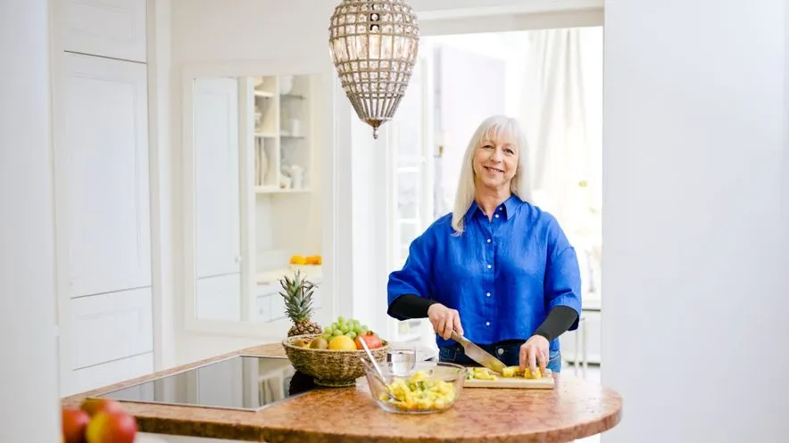 Trendfarben Model Ursula schneidet Obst als Element einer mediterranen Ernährung
