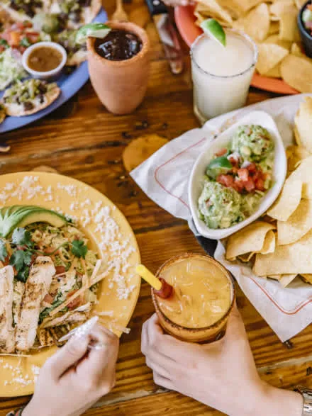 Übersicht des Ojos Locos Menüs mit verschiedenen Vorspeisen und Getränken in einer Sportbar-Umgebung.