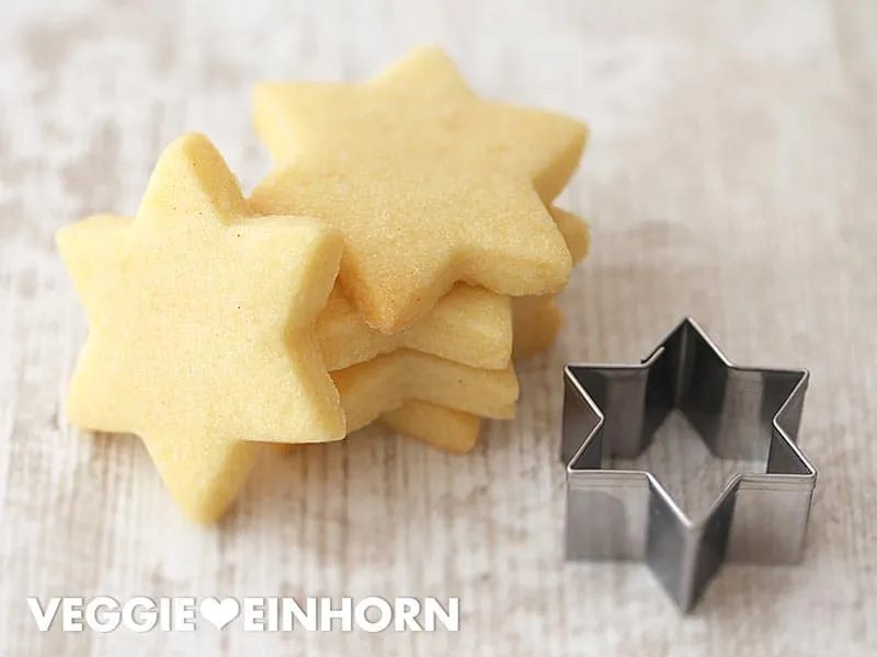 Vegane Plätzchenteig auf Holzbrett mit Ausstechformen