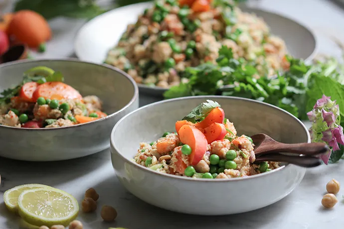 Veganer Aprikosen-Couscoussalat mit Kichererbsen, Koriander und einem herrlichen Erdnuss-Limettendressing in einer Schale