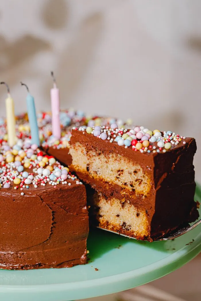 Veganer Geburtstagskuchen mit Schoko-Frosting und bunten Streuseln