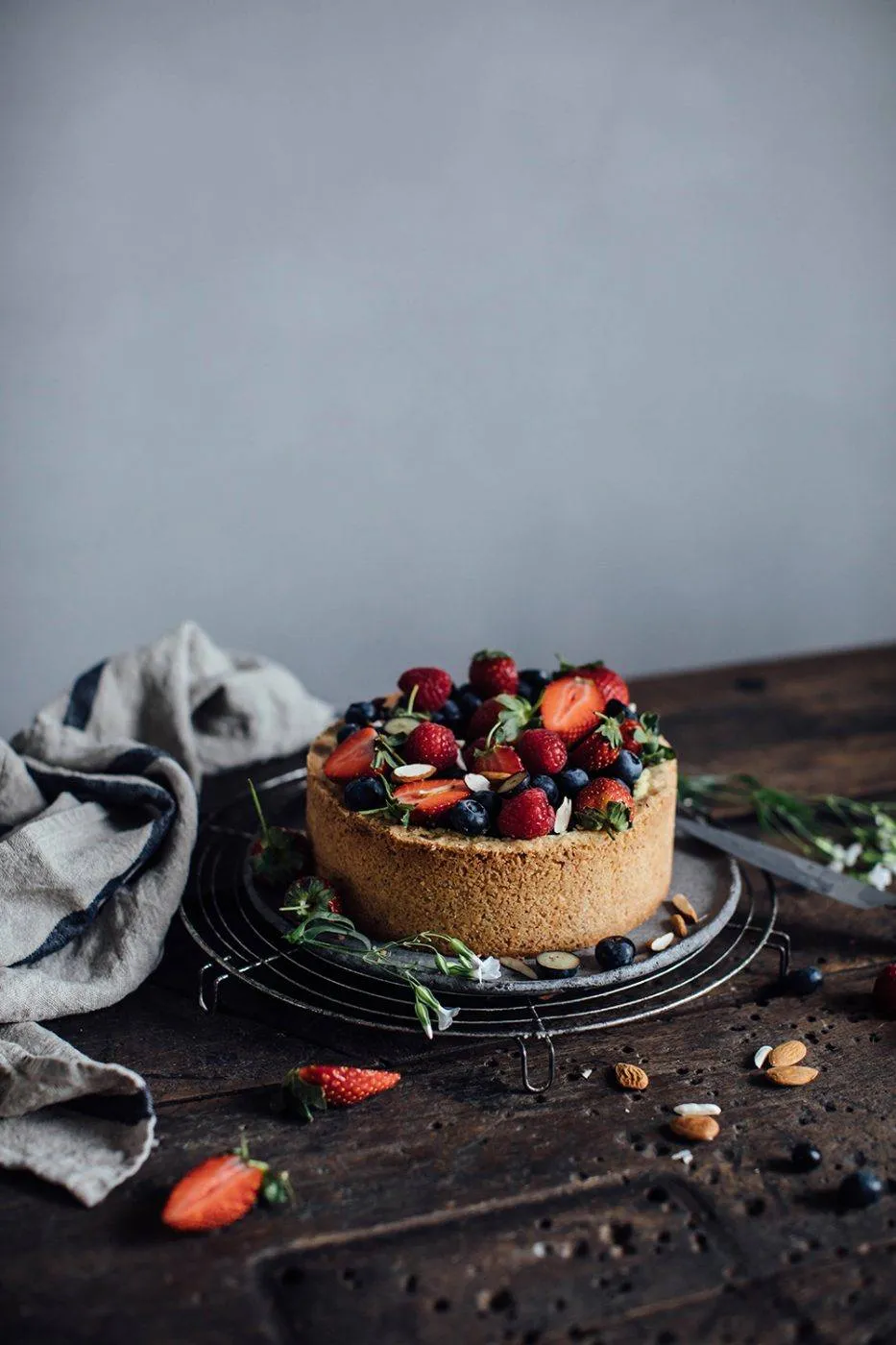 Veganer Käsekuchen mit Baileys Almande auf einem Teller, mit der Flasche im Hintergrund