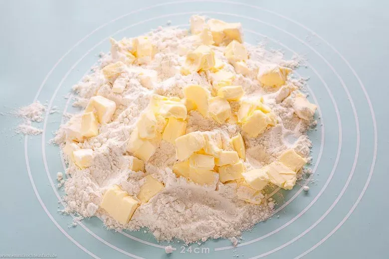 Verreiben von kalter Butter und Mehl für einen mürben Quiche Teig.