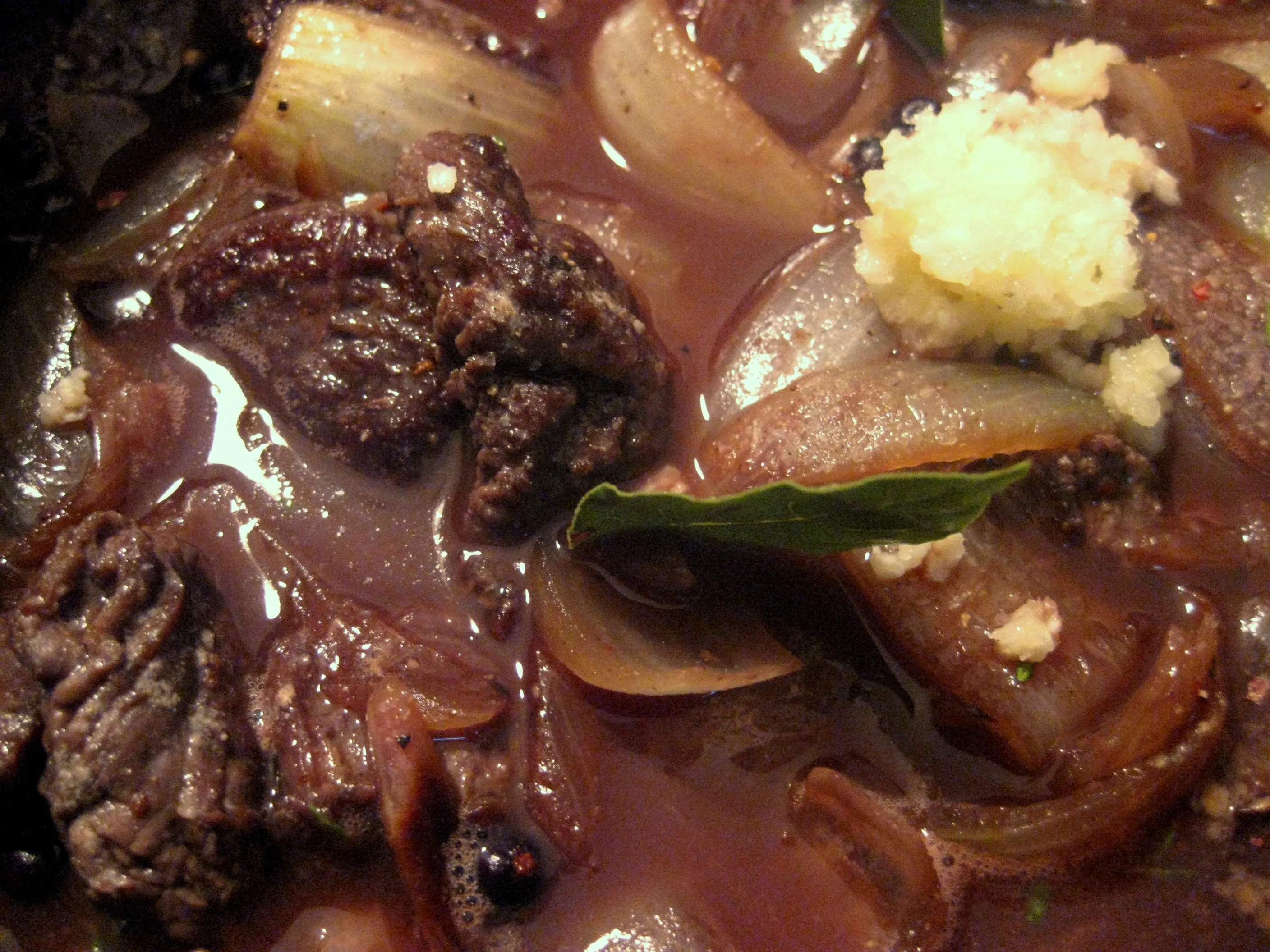 Verschiedene Gewürze und Kräuter werden zu dem Gulasch in den Topf gegeben.