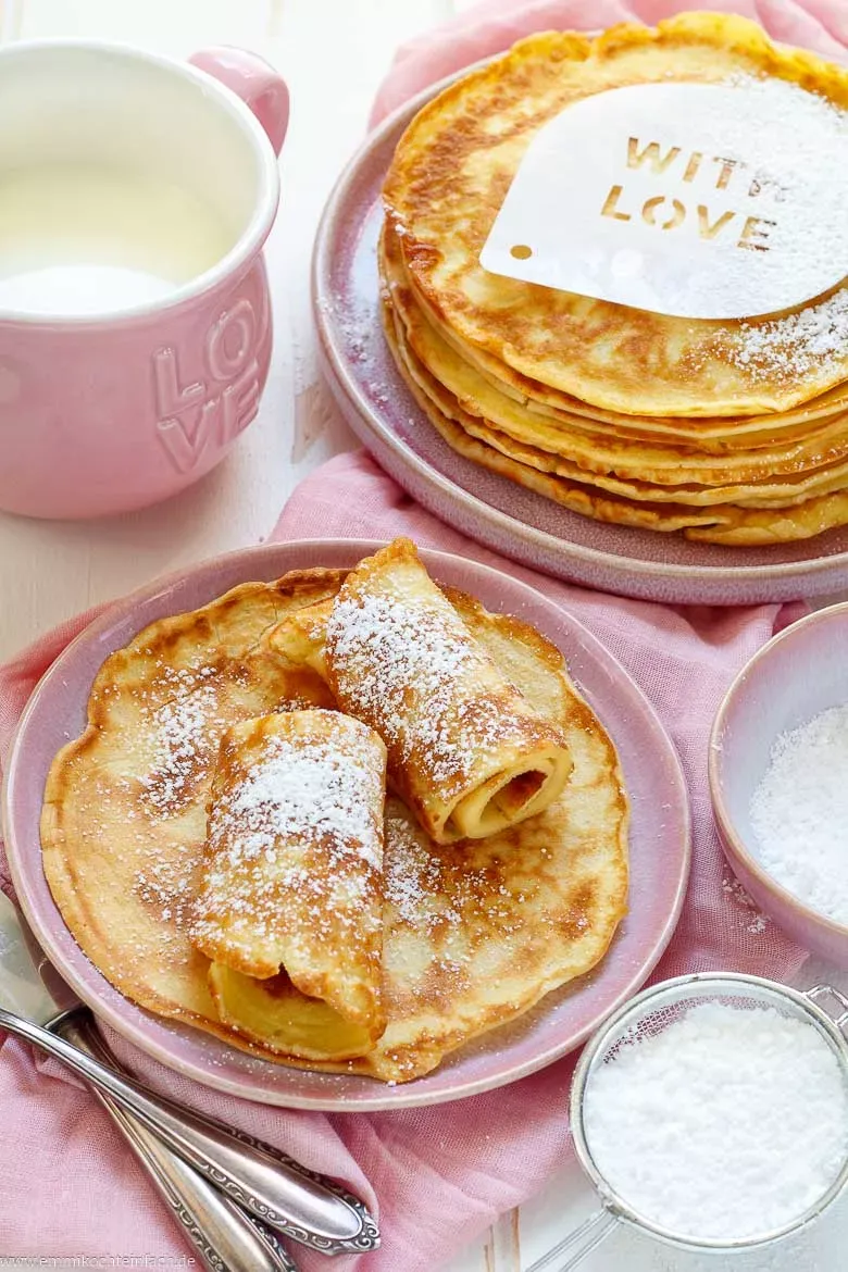 Verschiedene Pfannkuchen-Variationen, süß mit Früchten und herzhaft mit Käse und Kräutern, appetitlich angerichtet.