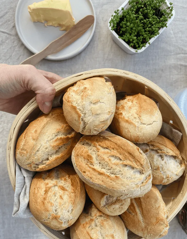 Verschiedene Stadien der Brötchenzubereitung: Teig, geformte Brötchen und fertig gebacken