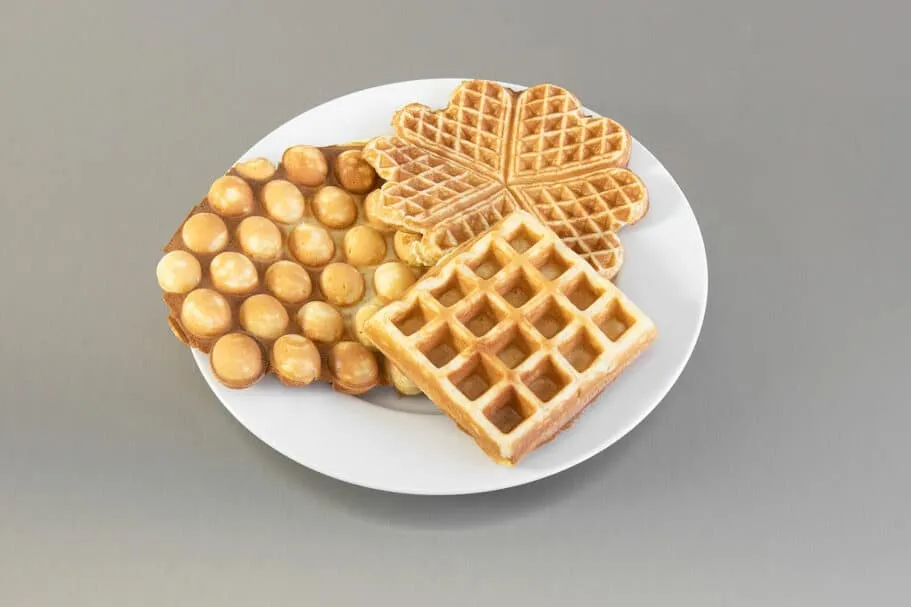 Verschiedene Waffelarten auf einem Teller, inklusive Herz- und Belgischen Waffeln