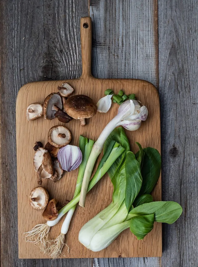 Verschiedene Zutaten für schnelle Ramen Suppe: Pak Choi, Shiitake Pilze und Ingwer liegen bereit.