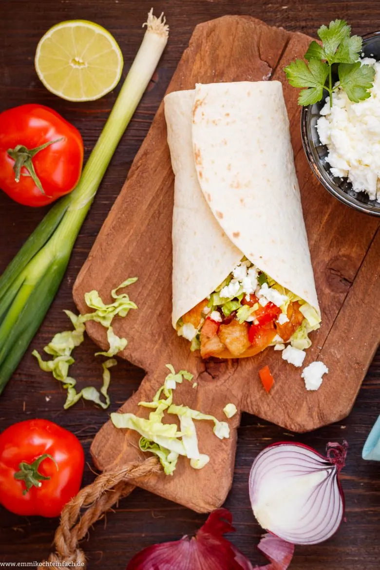 Vielfältige frische Zutaten für Wraps: Hähnchenbrust, Feta, Avocado, Limette, Gemüse