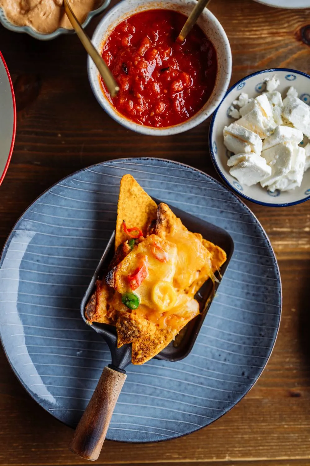 Vielfältige Raclette-Zutaten: Gemüse, Saucen und Käse auf einem gedeckten Tisch