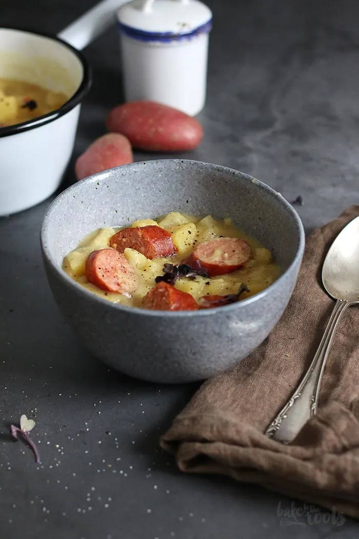 Vier herzhafte Rauchenden (Knackwürste), traditionelle Beilage zur deutschen Kohlrabisuppe, auf einem Holzbrett.