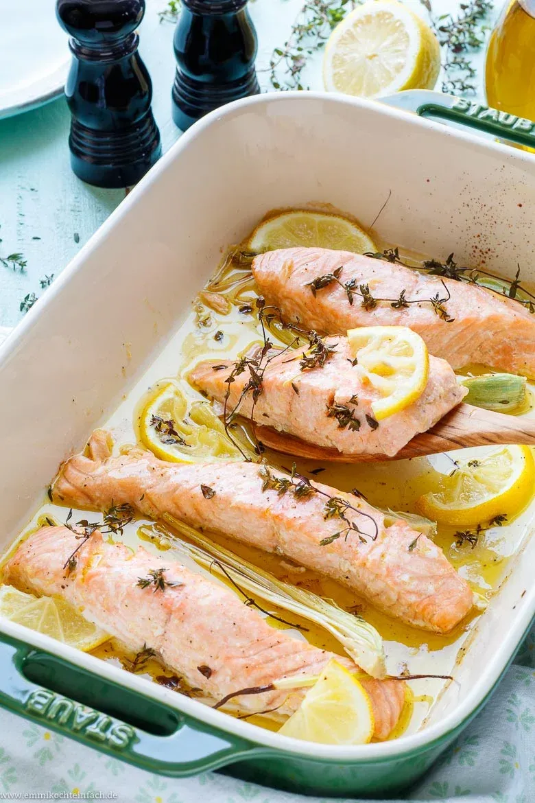 Vier rohe Lachsfilets in einer Auflaufform, bereit für die Zubereitung im Ofen mit mediterranen Gewürzen für ein einfaches Lachsfilet Rezept.