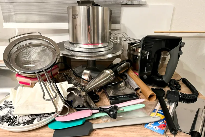 Vollständige Liste des benötigten Equipments für eine zweistöckige Hochzeitstorte, ausgebreitet auf einem Tisch