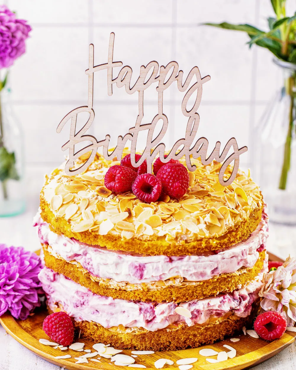 Von oben gesehen: Himbeer-Quark Naked Cake mit frischen Beeren und einem "Happy Birthday" Tortenaufsatz