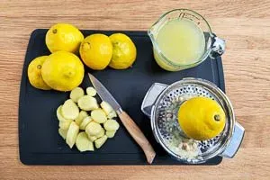 Vorbereitungsschritt für Ingwer Shot: geschälter Ingwer und frisch halbierte Zitronen