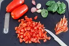 Vorbereitungsschritte für den Bruschetta Belag: Tomaten würfeln und Basilikum zupfen