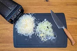 Vorbereitungsschritte: Zwiebeln und Knoblauch schälen und schneiden, Parmesan fein reiben für das Hackbällchen Rezept