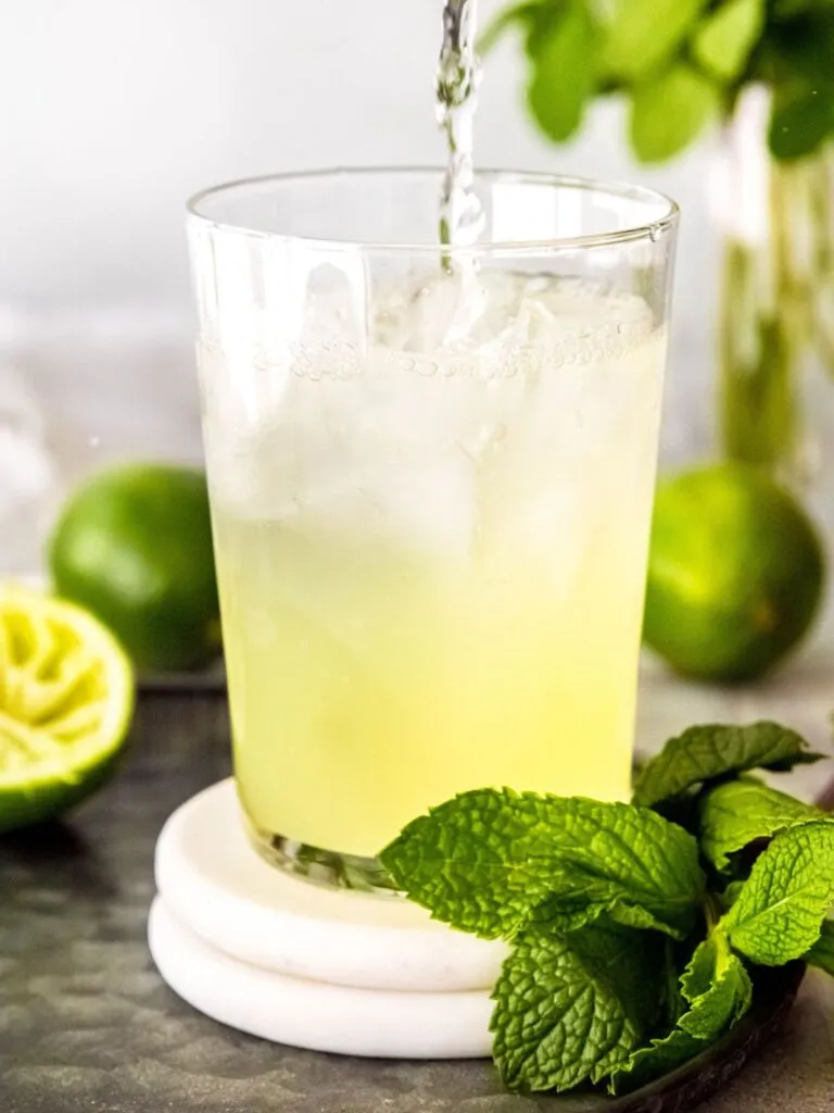 Wasser wird über die Cool Lime Refresher Basis gegossen, um das Getränk zu verdünnen.