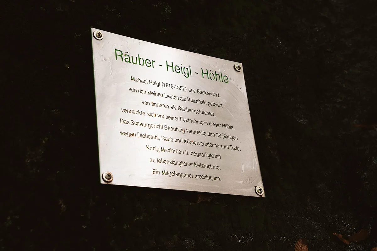 Wegweiser Schild an der Räuber Heigl Höhle im Wald