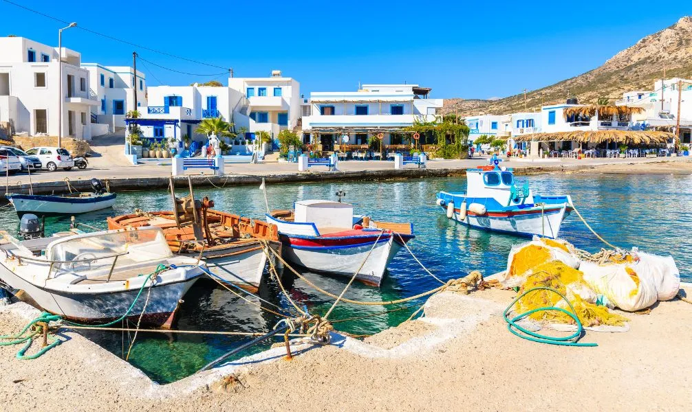 Weiß getünchte Häuser und eine blaue Kuppelkirche auf Santorin, ein klassisches griechisches Urlaubsziel im September