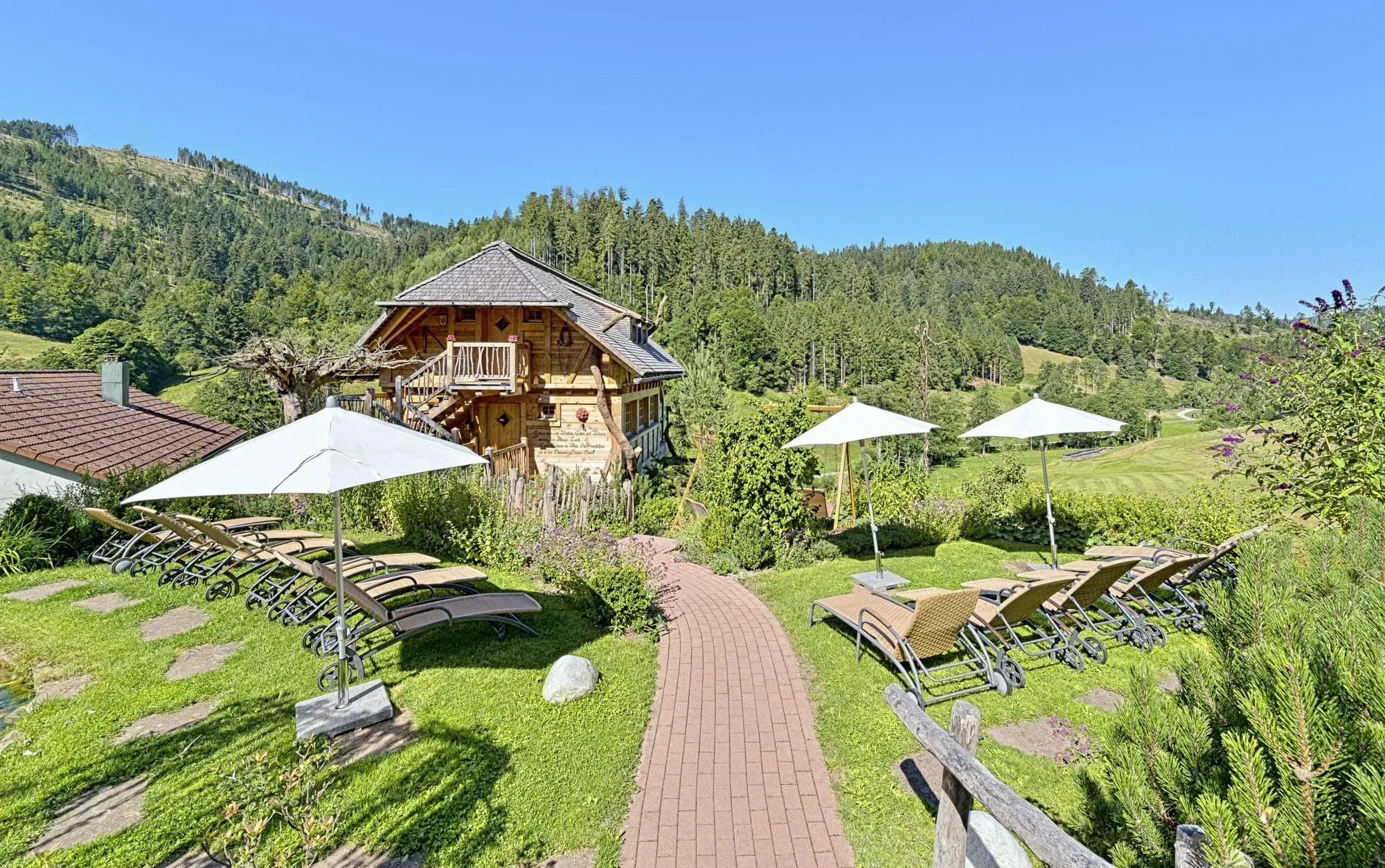 Wellnessgarten im Sommer mit Liegestühlen und Blick ins Tonbachtal im Schwarzwald