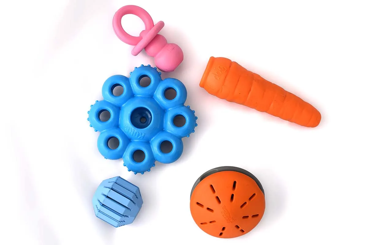 Welpe spielt mit einem interaktiven Kauspielzeug, ideal zum Stressabbau und zur Zahnungshilfe.