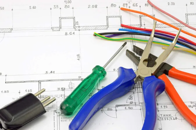Werkzeuge und Kabel auf einem Plan zur Industriemeister-Elektrotechnik-Ausbildung
