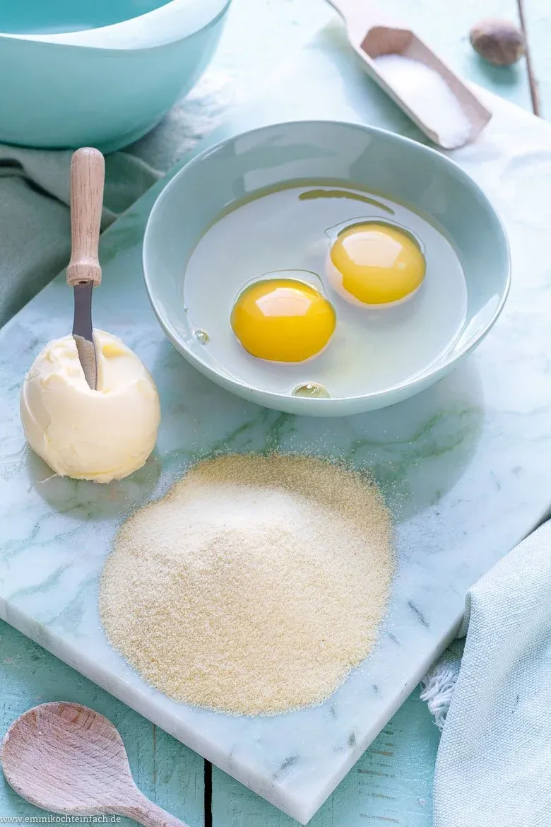 Wichtige Zutaten für unser Grießklößchen Rezept: Hartweizengrieß, Butter und Eier, bereit zur Verarbeitung.