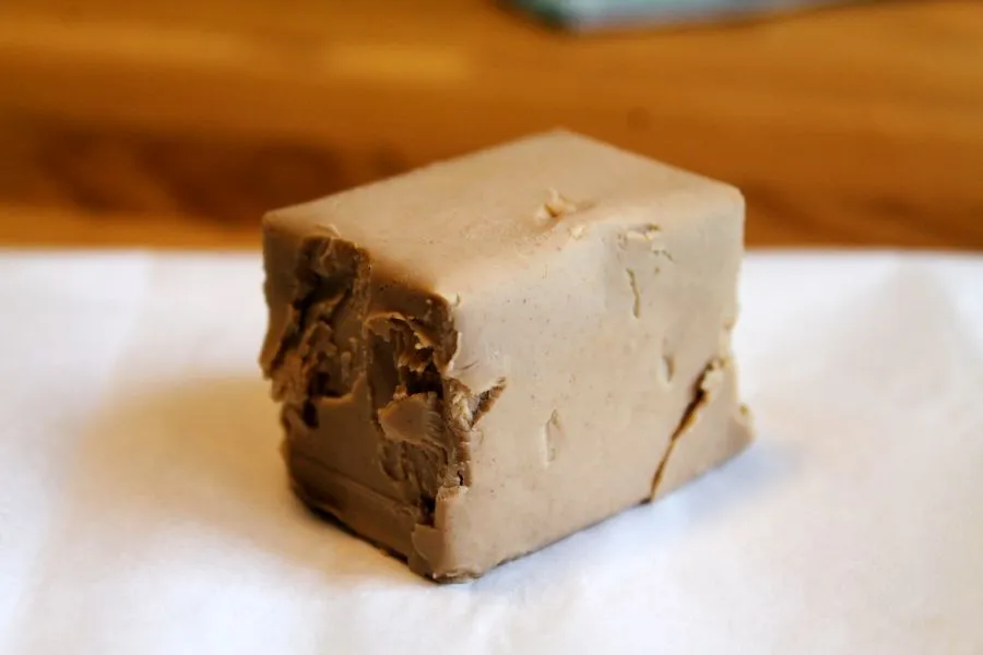 Würfel frische Hefe auf weißem Papier, wichtig für luftige Brötchen.