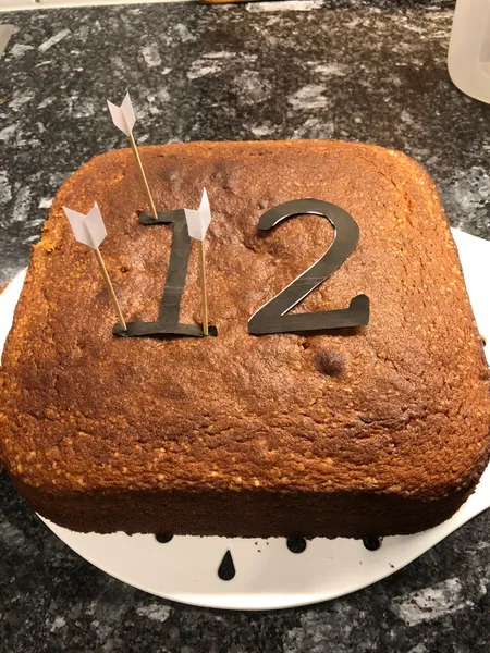 Zahlenkuchen vorbereiten: Eine Schablone auf dem Kuchen fixieren und die Zahl vorsichtig ausschneiden.