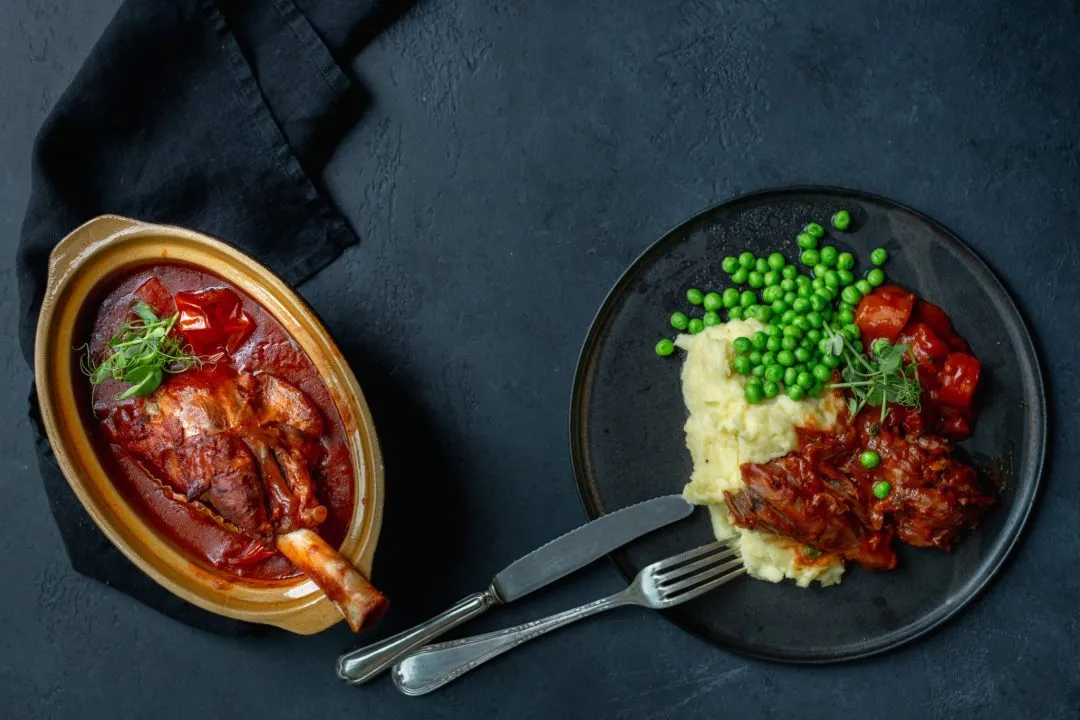 Zart geschmorte Lammstelze mit cremigem Erdäpfelpüree, bereit zum Servieren