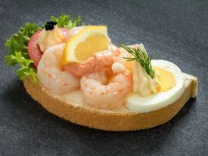 Zarte Garnelen auf einem dekorierten Brötchen