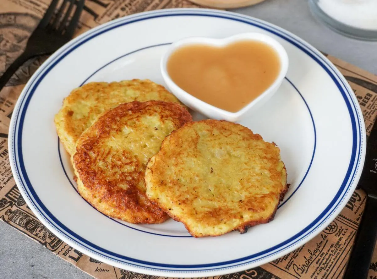 Zarte goldbraune Kartoffelpuffer, perfekt zubereitet mit dem Thermomix, serviert mit Apfelmus