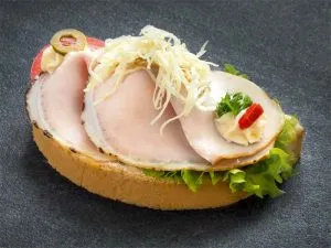Zarter Braten vom Schweinskarree auf einem Schwarzbrotbrötchen