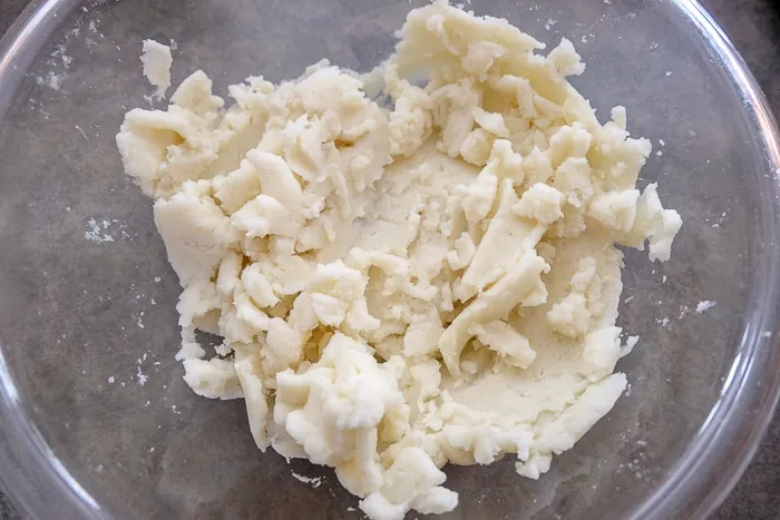 Zerdrückte Kartoffeln in einer Glasschüssel, als Basis für den Schupfnudeln Teig.