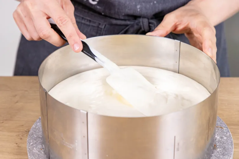 Zitronen-Joghurt-Creme auf dem Tortenboden in der Springform verteilen