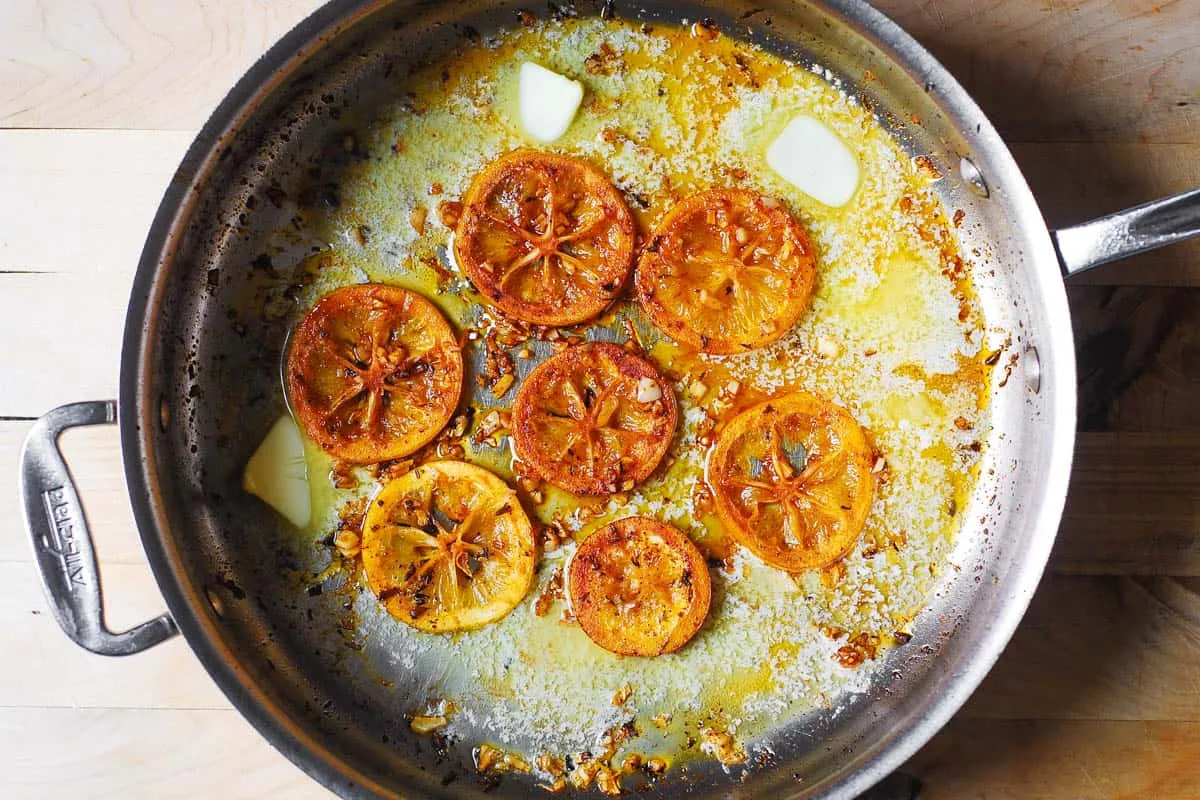 Zitronen-, Knoblauch- und Buttersoße köchelt sanft in der Pfanne, bereit, die Spaghetti aufzunehmen.