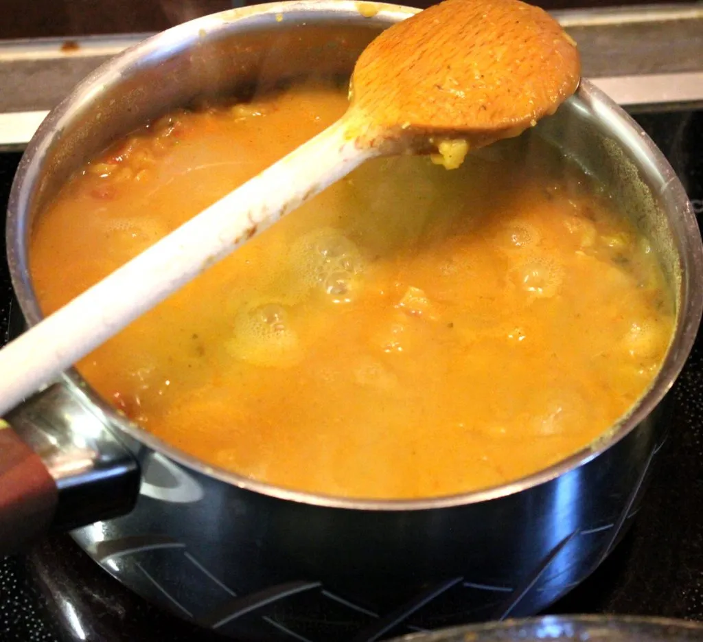 Zubereitung der Tadka: Kreuzkümmel und Knoblauch in Öl anbraten