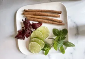 Zubereitungsschritt: Ein Dominican Mule wird mit Eis und frischen Garnituren wie Limette und Minze versehen